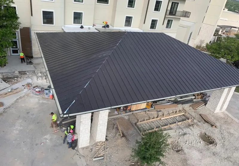 Metal roofing installation team working on a commercial building in Chackbay